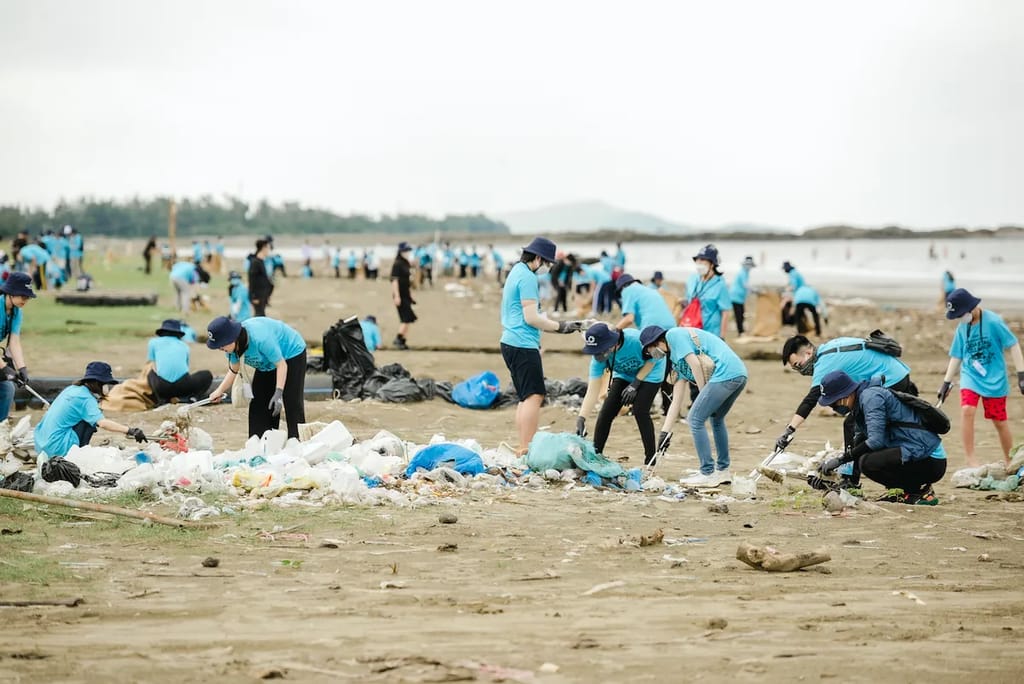 Volunteers pick up trash on a beach in Vietnam