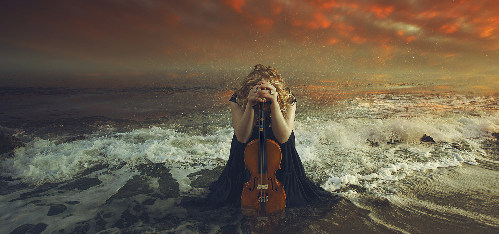Women in the ocean with violin