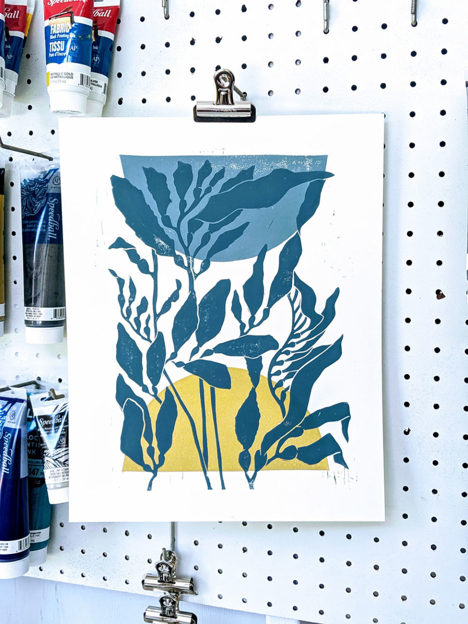 An art piece from Joan P. Bogart depicting the sun and moon behind sea kelp.