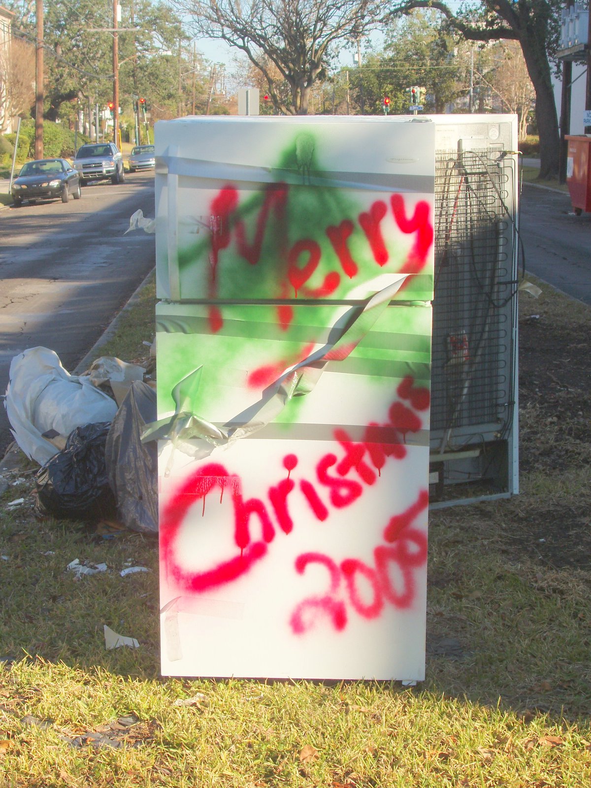 A white, abandoned fridge with Merry Christmas 2005 spray painted on.