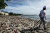 Man walking Playa Gringo beach during cleanup