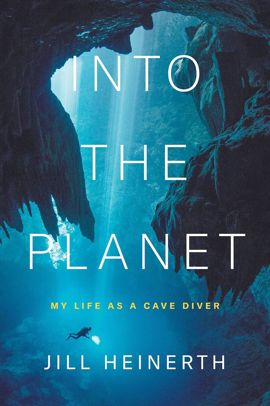 The cover of the book Into the Planet: My Life as a Cave Diver by Jill Heinerth depicts a person cave diving in deep ocean waters.