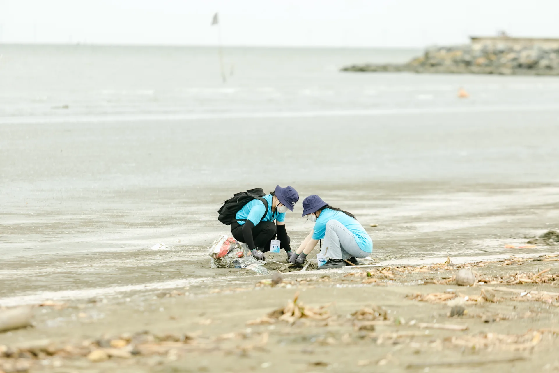 Two volunteers clean up a beach in Vietnam