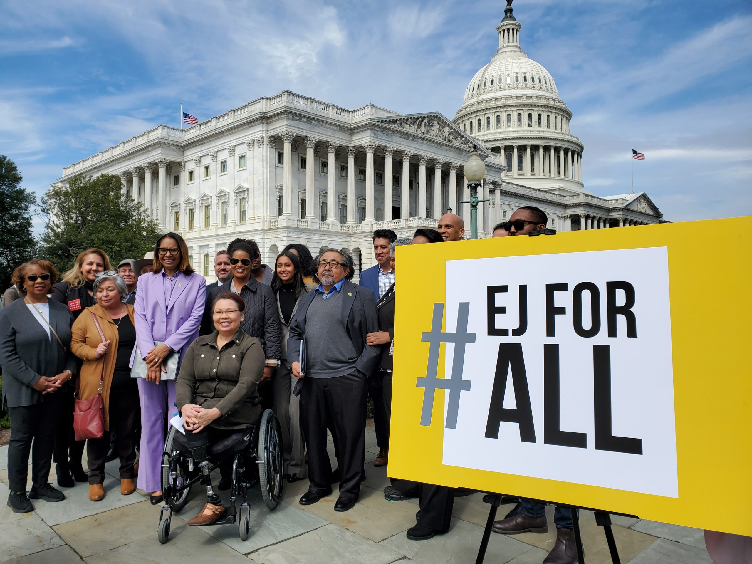 Elected representatives and activists at the U.S. Capitol with an easel carrying "#EJforAll."