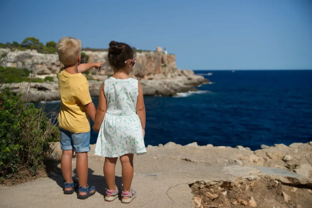 Two kids look out at the ocean