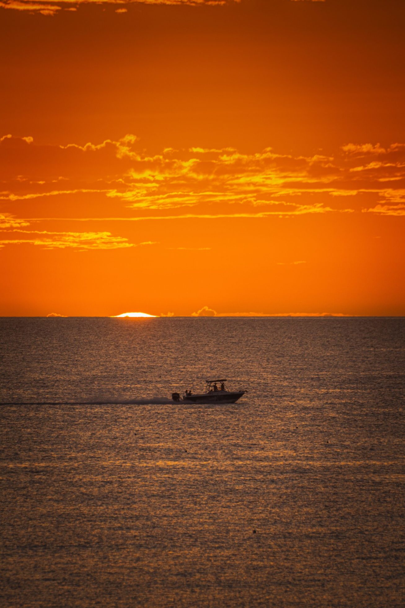 silhouette of boat on sea during sunset