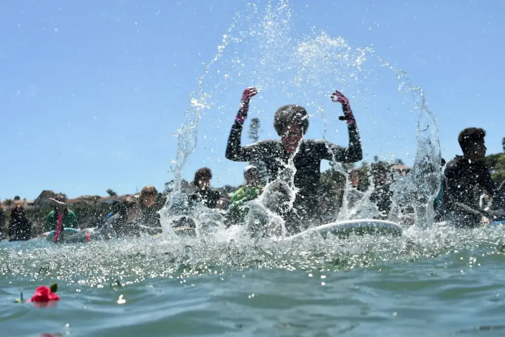 surfer splashes water and smiles