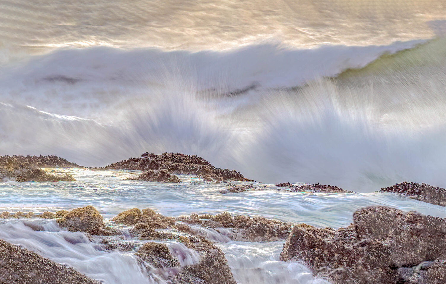 a beautiful coastline with waves crashing against brown rocks